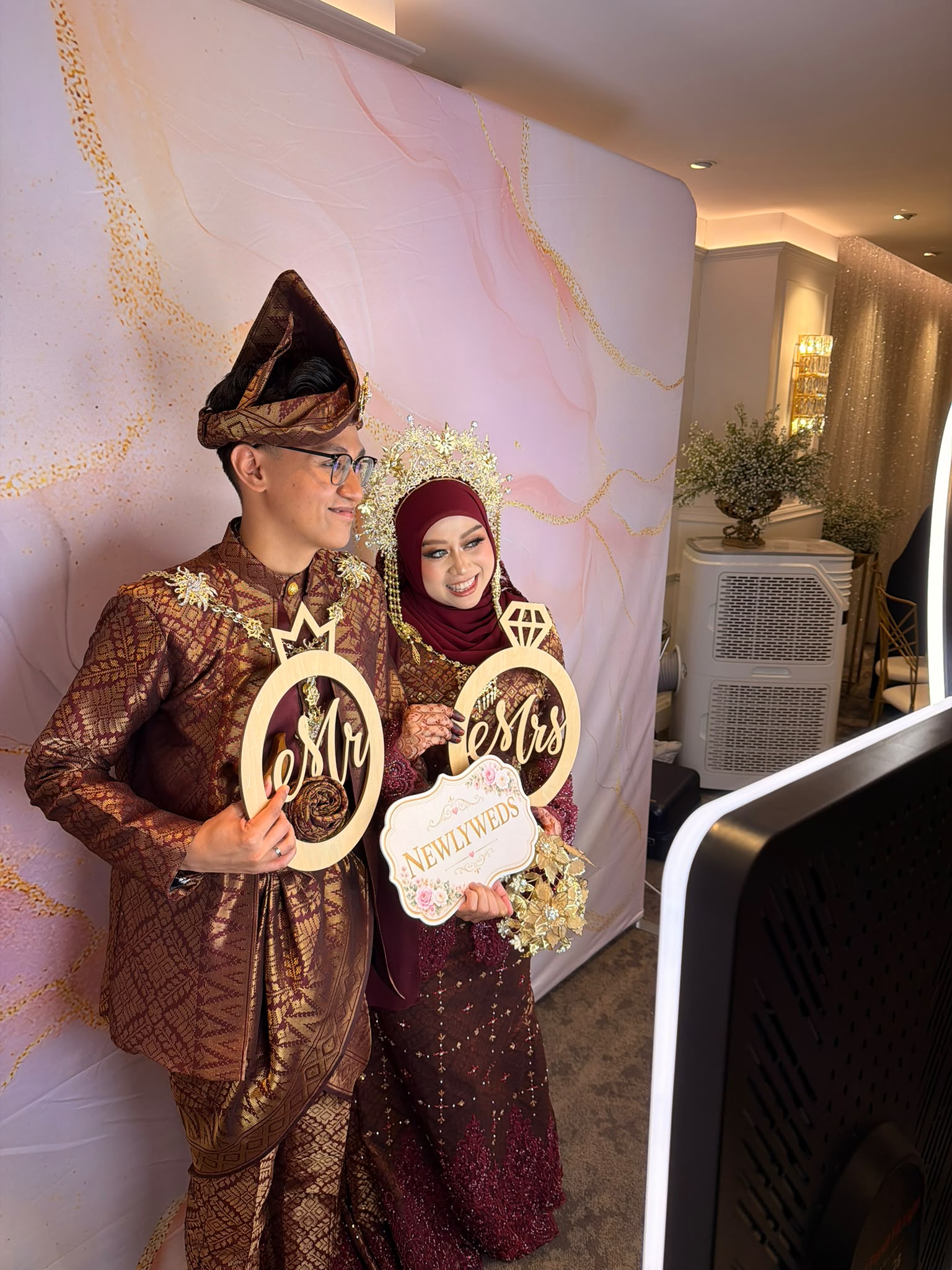 Wedding couple posing with signs at the photobooth