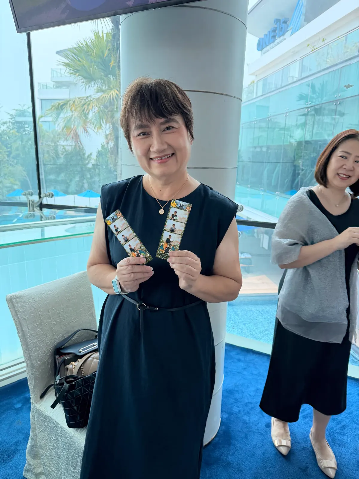 Wedding guest smiling and holding two freshly printed photo strips