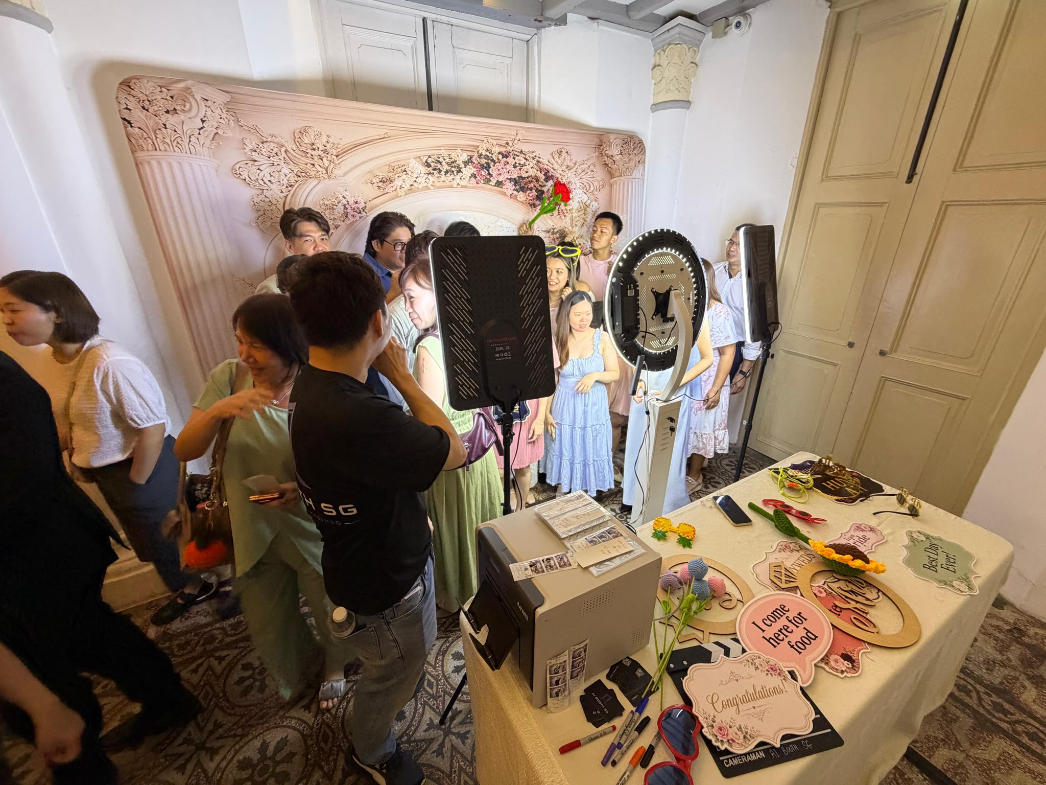 Wedding guests at AI Booth SG's photobooth with props table, ring light and instant printer