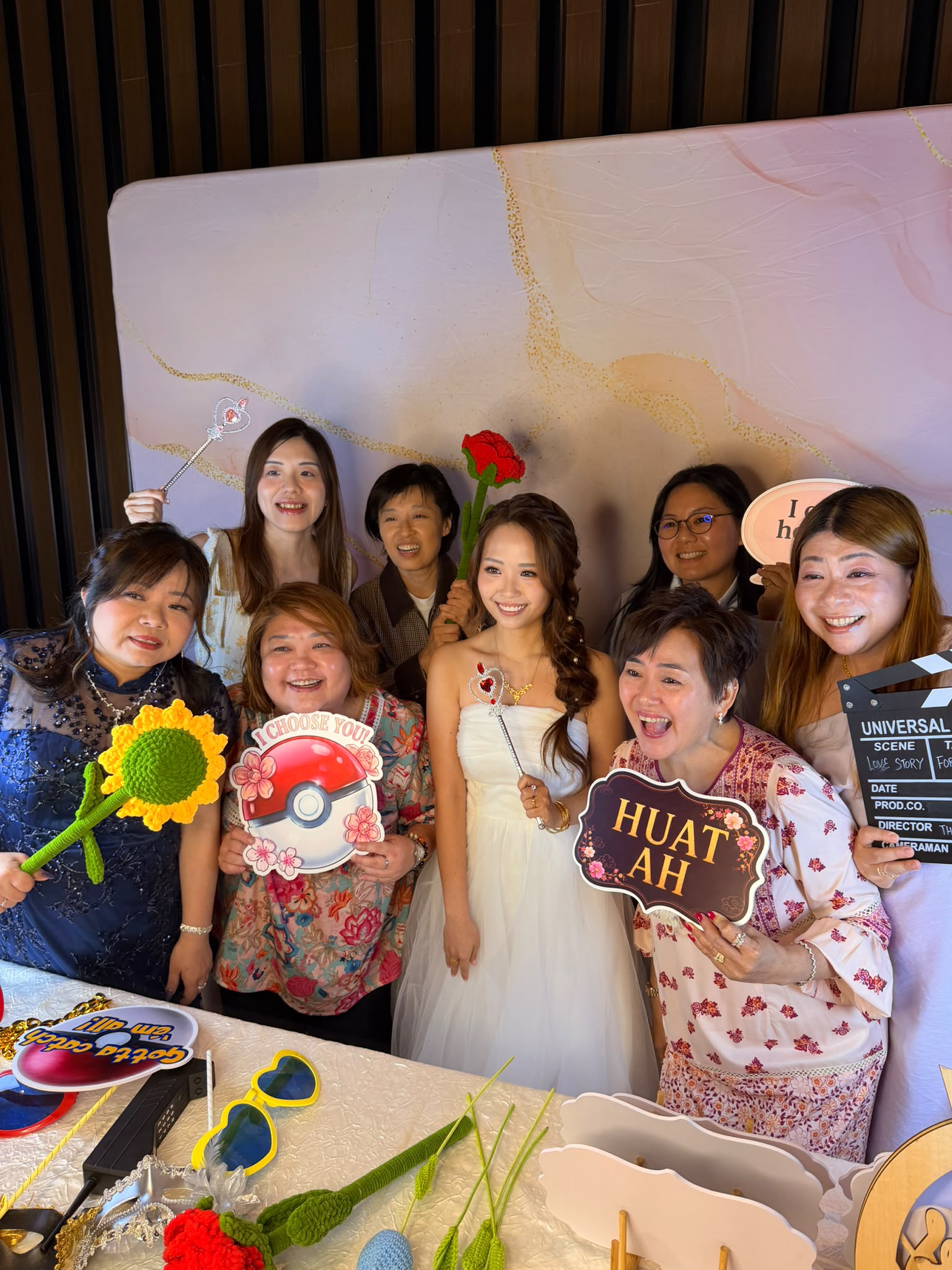 Wedding guests laughing and posing with colourful props at a real AI Booth SG event