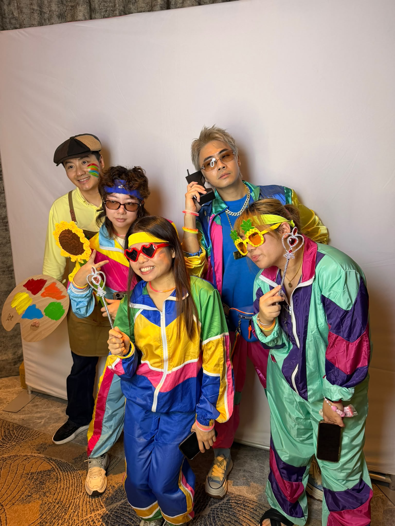 Colleagues in retro windbreakers at a real corporate D&D photobooth in Singapore